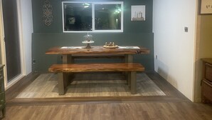 Une pièce avec une table à manger en bois, un banc et une fenêtre donnant sur un beau paysage.