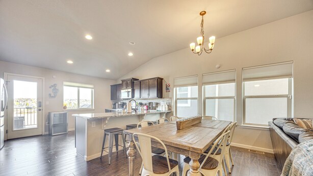 A spacious kitchen with a dining area, a built-in island, and a seating area with a sofa. - 8 Mi to USAFA! Townhome w/ Game Room & Backyard (Colorado Springs)