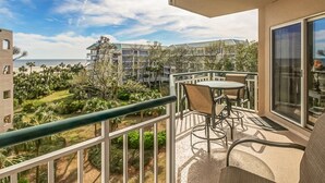 Un balcón con vista a una zona turística, con edificios y palmeras.