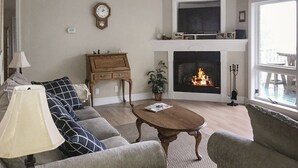 Un salon avec une cheminée, un canapé, une table basse et une lampe.