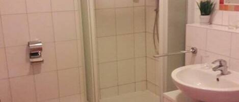 A bathroom with a shower, toilet, and sink.