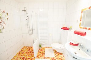 A bathroom with a shower, toilet, and sink. - Pension Village (Naumburg)