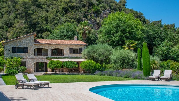 A stone villa with a swimming pool, surrounded by lush greenery and a mountainous backdrop. -  Big pool (19m), large beds, AIRCON, fast WIFI, EV charger, BBQ, peace and quiet (Cagnes-Sur-Mer)