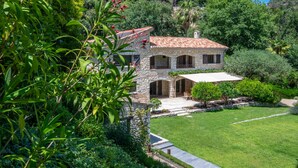 A stone villa with a tiled roof, a covered patio, and a well-maintained lawn. -  Big pool (19m), large beds, AIRCON, fast WIFI, EV charger, BBQ, peace and quiet (Cagnes-Sur-Mer)