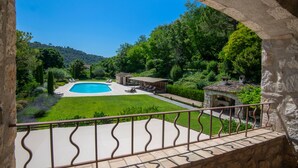 A pool with a stone structure, a lawn, and a stone building in a garden. -  Big pool (19m), large beds, AIRCON, fast WIFI, EV charger, BBQ, peace and quiet (Cagnes-Sur-Mer)