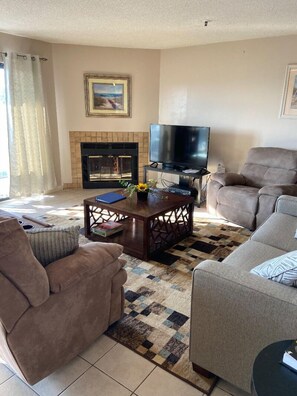 A living room with a fireplace, a television, and two sofas.