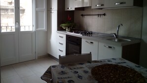 Een moderne keuken met witte kasten, een inbouwoven en een roestvrijstalen spoelbak.