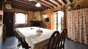 A rustic kitchen with a wooden table, chairs, a stove, and a window. - Country Cottage / Gite - Siracusa (Siracusa)