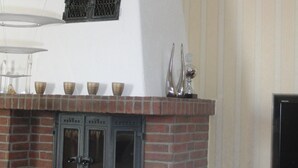 Ett vardagsrum med en öppen spis, en tv och en modern lampa.