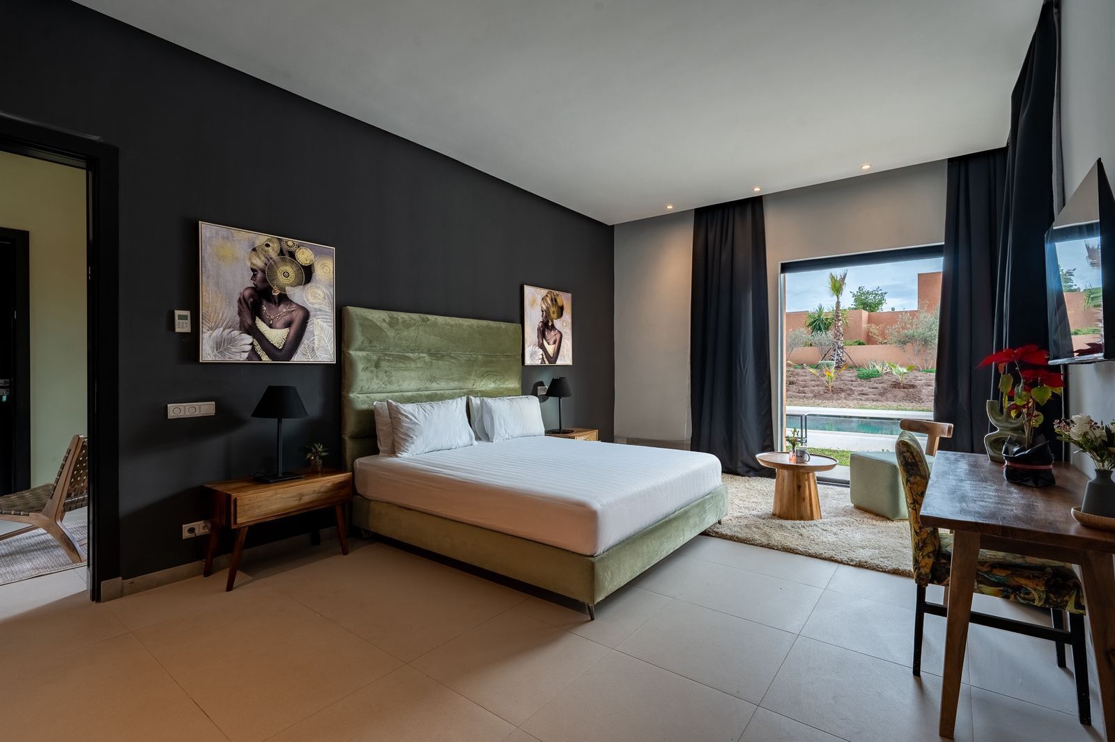 Habitació d'hotel moderna amb un llit gran, una taula de treball i vistes a l'exterior.