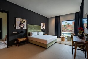 Habitación de hotel moderna con una cama grande, un escritorio y vistas al exterior.