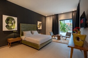 A modern bedroom with a large bed, bedside tables, a desk, chairs, and artwork on the walls. - Villa 865 + (Marrakech)
