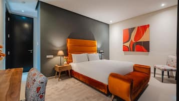 Una camera d'albergo moderna con un grande letto, un comodino, una scrivania e una sedia.