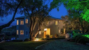 Une maison à deux étages, dotée d’une entrée bien éclairée et d’une voiture garée dans l’allée.