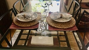 Une table à manger dressée avec des assiettes, des verres et un set de table.