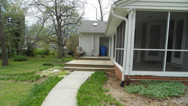 A residential house with a front porch, a visible blue door, and a covered outdoor area.