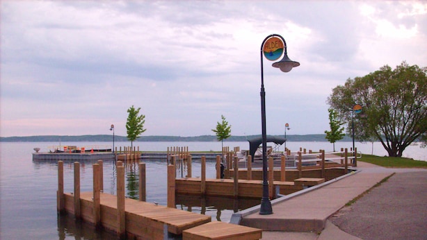 Une jetée au bord du lac, avec des bancs en bois et un lampadaire.
