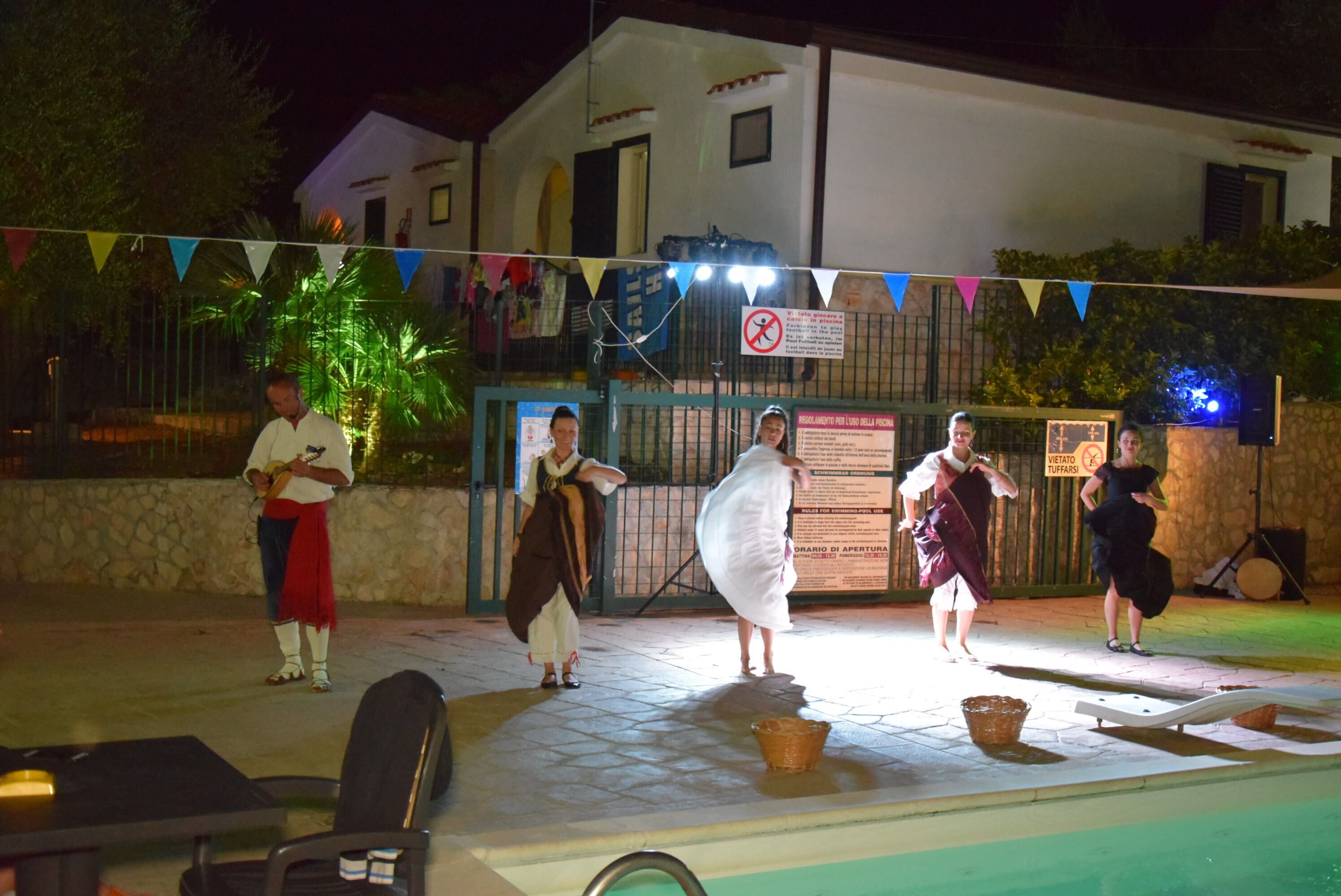 A group of people performing in an outdoor setting at night.