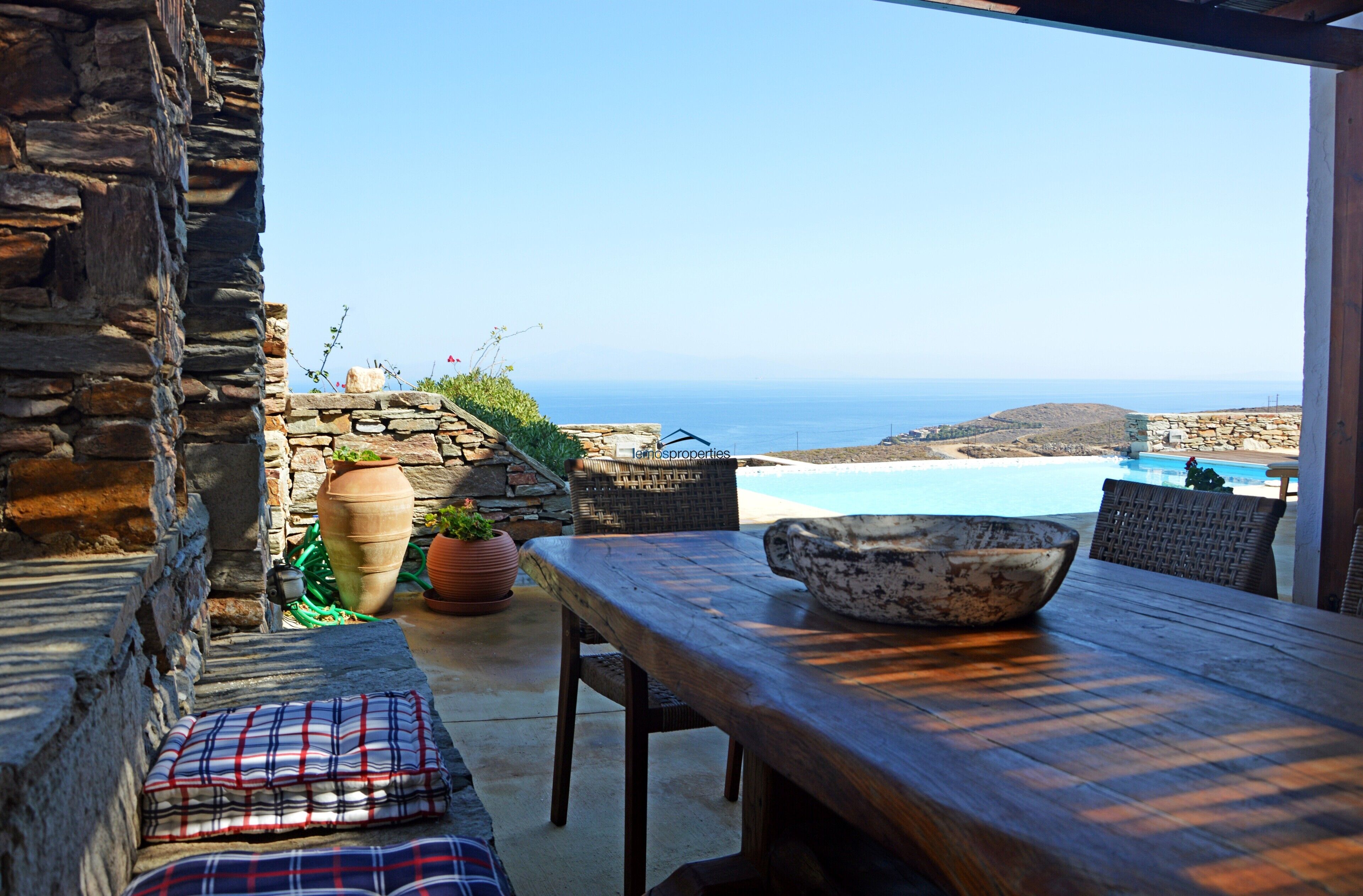 The shaded dining area with a pool an sea view