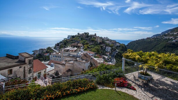 Eine Küstenstadt mit historischen Gebäuden, einem Steinweg und Blick auf das Meer.