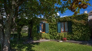Ein Haus mit gepflegtem Rasen und einem Baum im Vordergrund.