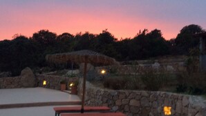 Vista al tramonto con posti a sedere all'aperto e pareti in pietra.
