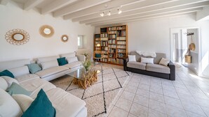 Una sala de estar amplia con una estantería grande, un sofá y una mesa de centro.