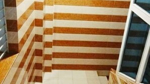 A staircase with striped tile walls and a window on the right. - Hotel Shalimar Int'l (Dhaka)