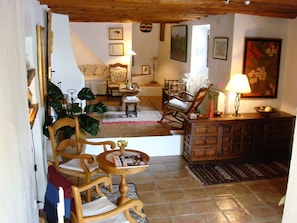 A cozy living room with a fireplace, wooden furniture, and a dining area with a table and chairs.