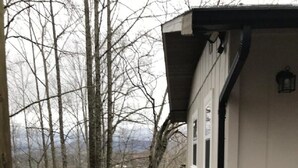 A wooden staircase leading to a white building with a metal barrel near the entrance. - HOTLIPS AT COLLINWOOD upstairs Price is on the website  Down stairs $125 extra (Hiawassee)