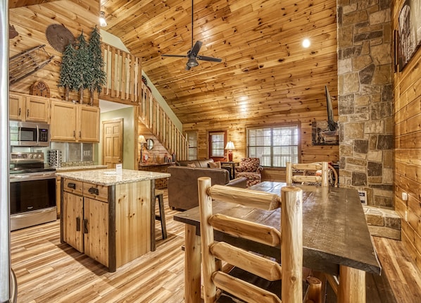 Cozy cabin-style interior with a spacious kitchen, comfortable seating area, and a fireplace.