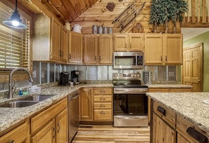 Enjoy cooking in this well-equipped kitchen with a sink, stove, oven, and microwave.