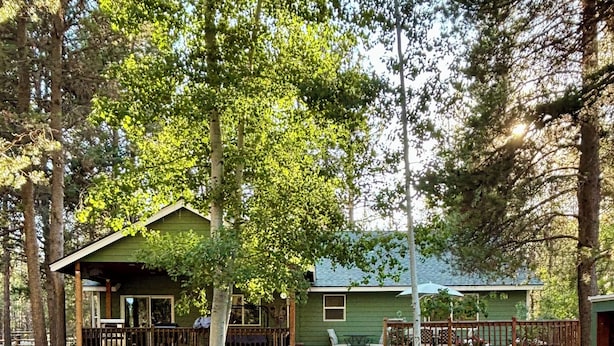 A wooden deck with Adirondack chairs, a fire pit, and picnic tables. - Welcome To Our "Home To The Outdoors" (La Pine)