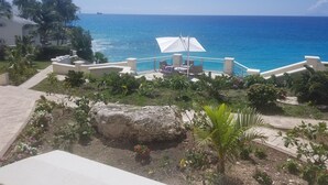Ein Resort mit Poolbereich, Außenbereich zum Sitzen und Blick auf den Ozean.