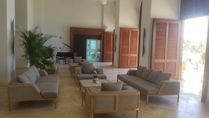 Eine großzügige Lobby mit Klavier, Sofas und einer großen Pflanze.