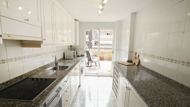 A modern kitchen with white cabinets, granite countertops, a built-in oven, and a sink. - A93 SENIA ESC C  2º I (Calpe)