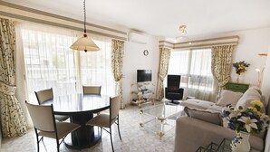 A living room with a round dining table, a sofa, a TV, and a coffee table. - A93 SENIA ESC C  2º I (Calpe)