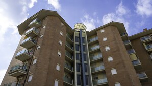 A multi-story residential building with balconies and a central cylindrical structure.