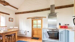 Una cucina con pavimento in legno, un fornello e una finestra.
