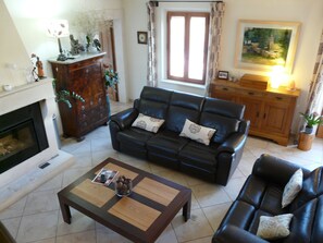 A living room with a fireplace, a sofa set, a coffee table, and a painting on the wall. - Vacation rental SAINT REMY DE PROVENCE LS1-196 (Saint Remy de Provence)