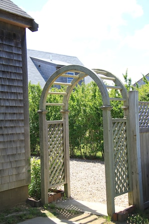 Enter a serene oasis beneath a charming arbor gateway.