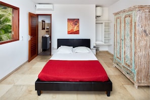 Une chambre à coucher avec un lit, une armoire, une salle de bain et une fenêtre.