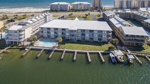 Ein Resort mit mehreren Gebäuden, einem Schwimmbad und angestaubten Booten.