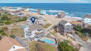 A coastal residential area with beachfront properties, including houses with balconies and a swimming pool.