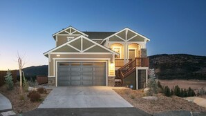A two-story house with a garage, a covered front porch, and a staircase leading to the second floor.