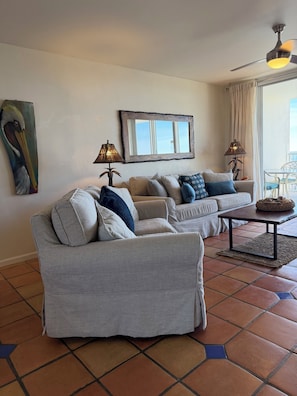A living room with two grey sofas, a coffee table, and a ceiling fan.