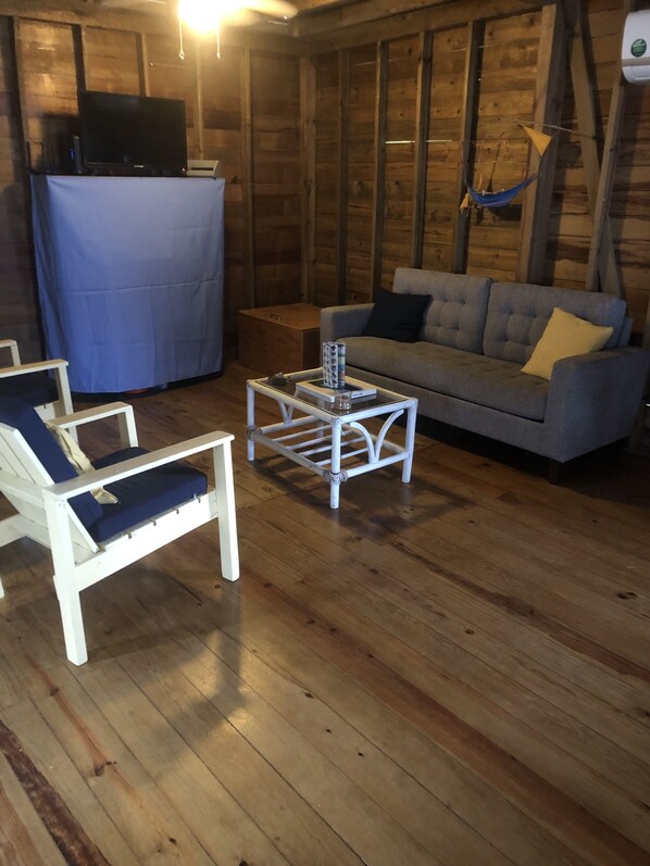 A wooden interior with a sofa, a white coffee table, and a blue chair. - Oceanfront and Convenient Location (bocas del toro)