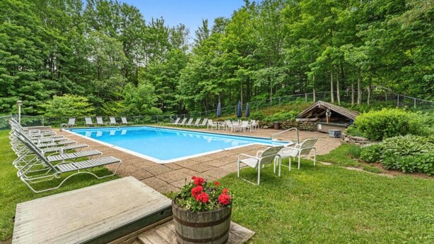A rectangular swimming pool surrounded by lounge chairs and a wooden deck. - Spacious Sugarbush Retreat - Wood Stove, Outdoor Pool, 5 Mins to Sugarbush (Warren)