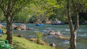 Ein Fluss mit einem Floß, umgeben von Steinen und Bäumen.