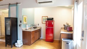 Eine kleine Küche mit Kühlschrank, Mikrowelle und Spüle.